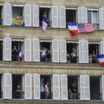 FRANCE - JULY 26: People wave from balconies during the opening ceremony of the Paris 2024 Olympic Games on July 26, 2024 in Paris, France. (Photo by Lee Jin-man - Pool/Getty Images)