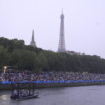 PARIS, FRANCE - JULY 26: Crowds along the Seine River watch the opening ceremony of the Paris 2024 Olympic Games on July 26, 2024 in Paris, France. (Photo by Aijaz Rahi - Pool/Getty Images)