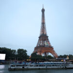 PARIS, FRANCE - JULY 26: Misaki Emura and Shigekix, Flagbearers of Team Japan, are seen on a boat waving their flag along the River Seine in front of the Eiffel Tower as during the opening ceremony of the Olympic Games Paris 2024 on July 26, 2024 in Paris, France. (Photo by Justin Setterfield/Getty Images)