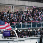 PARIS, FRANCE - JULY 26: Athletes of Team United States wave flags on the athletes' parade team boat along the River Seine  during the opening ceremony of the Olympic Games Paris 2024 on July 26, 2024 in Paris, France. (Photo by Jared C. Tilton/Getty Images)