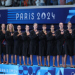 PARIS, FRANCE - JULY 27: Members of Team United States sing the national anthem before the Women's Preliminary Round - Group B match between Team Greece and Team United States on day one of the Olympic Games Paris 2024 at Aquatics Centre on July 27, 2024 in Paris, France. (Photo by Clive Rose/2024 Getty Images)