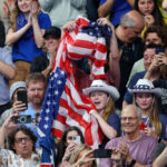 NANTERRE, FRANCE - JULY 27: A spectator with the flag of Team United States shows their support on day one of the Olympic Games Paris 2024 at Paris La Defense Arena on July 27, 2024 in Nanterre, France. (Photo by Sarah Stier/Getty Images)