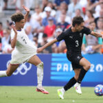 MARSEILLE, FRANCE - JULY 27: Sam Sutton #3 of Team New Zealand holds off a challenge from Kevin Paredes #7 of Team United States during the Men's group A match between New Zealand and United States during the Olympic Games Paris 2024 at Stade de Marseille on July 27, 2024 in Marseille, France. (Photo by Alex Livesey/Getty Images)