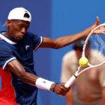 PARIS, FRANCE - JULY 28: Christopher Eubanks of Team United States plays a backhand against Benjamin Hassan of Team Lebanon during the Men’s Singles first round match on day two of the Olympic Games Paris 2024 at Roland Garros on July 28, 2024 in Paris, France. (Photo by Clive Brunskill/Getty Images)