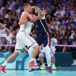 LILLE, FRANCE - JULY 28: Nikola Jokic #15 of Team Serbia drives to the basket against Anthony Davis #14 of Team United States during the second half of the Men's Group Phase - Group C game between Serbia and the United States on day two of the Olympic Games Paris 2024 at Stade Pierre Mauroy on July 28, 2024 in Lille, France. (Photo by Gregory Shamus/Getty Images)