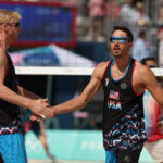 PARIS, FRANCE - JULY 29: Chase Budinger and Miles Evans of Team United States high five during the Men's Preliminary Phase - Pool F match against Team France on day three of the Olympic Games Paris 2024 at Eiffel Tower Stadium on July 29, 2024 in Paris, France. (Photo by Michael Reaves/Getty Images)