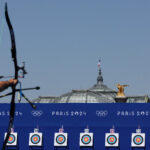 PARIS, FRANCE - JULY 29: An archer practices with the Grand Palais as a backdrop on day three of the Olympic Games Paris 2024 at Esplanade Des Invalides on July 29, 2024 in Paris, France. (Photo by Julian Finney/Getty Images)