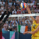 PARIS, FRANCE - JULY 29: Jonatan Hellvig of Team Sweden attacks the net against the block attempt by Cherif Younousse of Team Qatar during the Men's Preliminary Phase - Pool A match on day three of the Olympic Games Paris 2024 at Eiffel Tower Stadium on July 29, 2024 in Paris, France. (Photo by Michael Reaves/Getty Images)