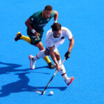 PARIS, FRANCE - JULY 30: Lukas Windfeder of Team Germany runs with the ball whilst under pressure from Keenan Horne of Team South Africa during the Men's Pool A match between South Africa and Germany on day four of the Olympic Games Paris 2024 at Stade Yves Du Manoir on July 30, 2024 in Paris, France. (Photo by Michael Reaves/Getty Images)