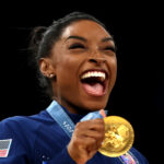 PARIS, FRANCE - JULY 30: Gold medalist Simone Biles of Team United States reacts on the podium during the medal ceremony for the Artistic Gymnastics Women's Team Final on day four of the Olympic Games Paris 2024 at Bercy Arena on July 30, 2024 in Paris, France. (Photo by Naomi Baker/Getty Images)