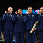 PARIS, FRANCE - JULY 30: (L-R) Gold medalists Simone Biles, Jade Carey, Jordan Chiles, Sunisa Lee and Hezly Rivera of Team United States celebrate on the podium during the medal ceremony for the Artistic Gymnastics Women's Team Final on day four of the Olympic Games Paris 2024 at Bercy Arena on July 30, 2024 in Paris, France. (Photo by Naomi Baker/Getty Images)