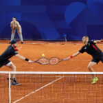 PARIS, FRANCE - JULY 30: Andy Murray of Team Great Britain and Dan Evans of Team Great Britain stretch for the same ball against Sander Gille of Team Belgium and Joran Vliegen of Team Belgium during the Men's Doubles second round match on day four of the Olympic Games Paris 2024 at Roland Garros on July 30, 2024 in Paris, France. (Photo by Clive Brunskill/Getty Images)