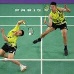 PARIS, FRANCE - AUGUST 02: Yang Lee of Team Chinese Taipei plays a shot behind his head as Wang Chi-Lin of Team Chinese Taipei watches on during the Men’s Doubles Semifinal match between Team Denmark and Team Chinese Taipei on day seven of the Olympic Games Paris 2024 at Porte de La Chapelle Arena on August 02, 2024 in Paris, France. (Photo by Julian Finney/Getty Images)