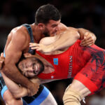 PARIS, FRANCE - AUGUST 06: Demeu Zhadrayev of Team Kazakhstan (red) competes with Sanan Suleymanov of Team Azerbaijan (blue) during the Wrestling Men's Greco-Roman 77kg Semifinal on day eleven of the Olympic Games Paris 2024 at Champs-de-Mars Arena on August 06, 2024 in Paris, France. (Photo by Sarah Stier/Getty Images)