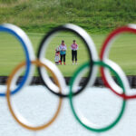 PARIS, FRANCE - AUGUST 08: Brooke M. Henderson of Team Canada looks across the 15th hole alongside her caddie, Brittany Henderson through the Olympic rings during Day Two of the Women's Individual Stroke Play on day thirteen of the Olympic Games Paris 2024 at Le Golf National on August 08, 2024 in Paris, France. (Photo by Kevin C. Cox/Getty Images)