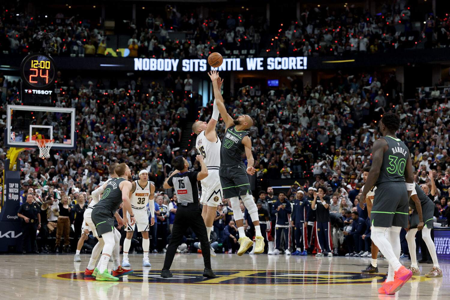 DENVER, COLORADO - APRIL 18: Nikola Jokic #15 of the Denver Nuggets tips off against 	Rudy Gobert #...