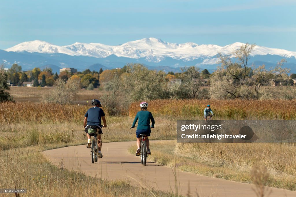 Riding the paved path around the lake with a snowy Mount Evans in the background, visitors enjoy ri...